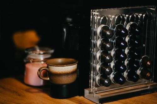a cup of coffee sitting next to a wine rack at Kedvesem Noszvaj in Noszvaj