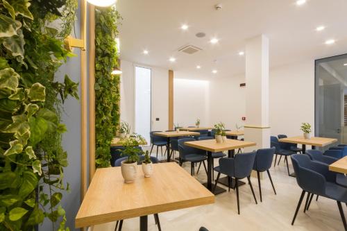 un restaurante con mesas, sillas y plantas en Hotel Bellavista - Boutique Hotel en Otranto