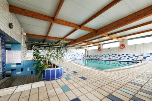 a large swimming pool with blue and white tiles at Hotel Juan de la Cosa in Santoña