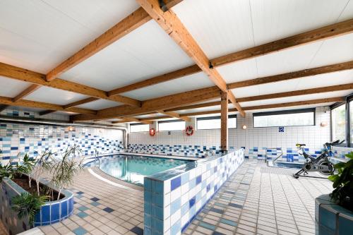 a swimming pool in a building with wooden beams at Hotel Juan de la Cosa in Santoña