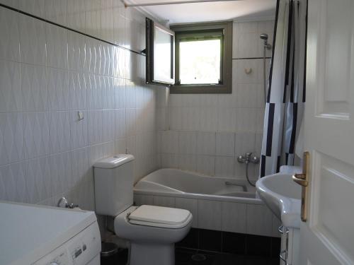 a bathroom with a toilet and a tub and a sink at Villa Kavos - Isthmia Corinth in Isthmia