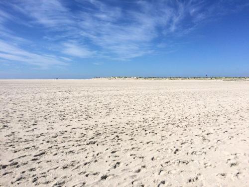 an empty beach with footprints in the sand at Ferienwohnung *Meeresleuchten* in Wittdün