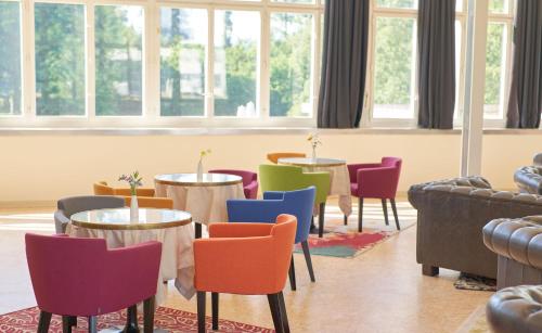 a room with tables and chairs and windows at Bata Club Haus in Möhlin
