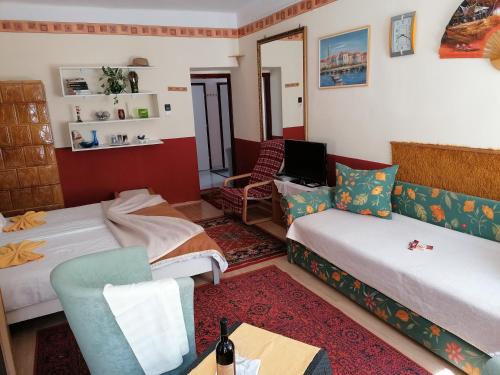 um quarto com duas camas e um sofá em Róza vendégszoba em Keszthely