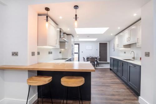 a kitchen with white cabinets and a wooden island with stools at The Old Hotel in York