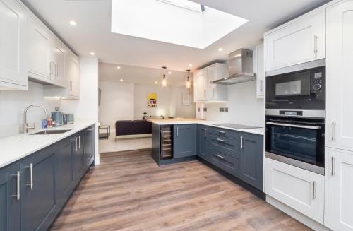 a kitchen with white cabinets and a sink and a stove at The Old Hotel in York