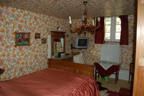 - une chambre avec un lit et une télévision murale dans l'établissement B&B Les Genêts, à Hatrival
