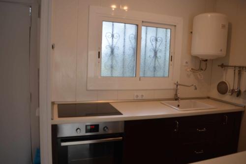 a kitchen with a sink and a window at Cala LLevado Tossa de M. A/C Parking Piscina in Tossa de Mar