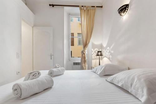 - une chambre blanche avec un grand lit et des serviettes dans l'établissement Magical Apartment, à Cannes