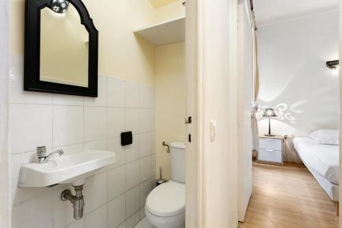 une salle de bain avec toilettes et lavabo et un lit dans l'établissement Magical Apartment, à Cannes