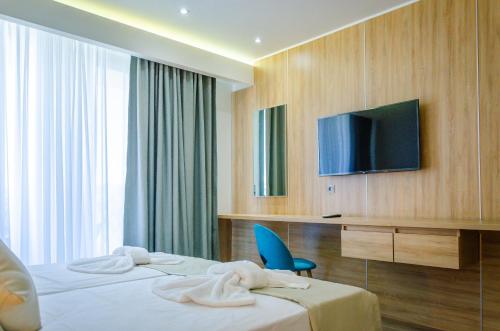 a hotel room with a bed and a television at Anassa Blue Thassos in Limenas