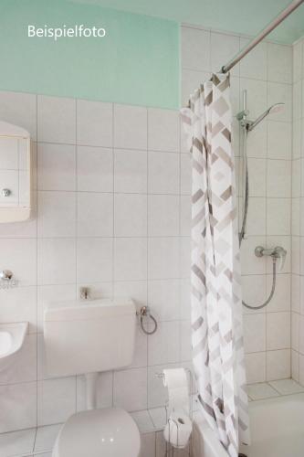 a bathroom with a toilet and a sink and a shower at Pension GP3, Zimmer mit Kochnische und Duschbad vor den Toren Berlins in Dallgow