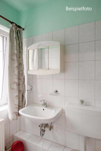 a white bathroom with a sink and a bath tub at Pension GP3, Zimmer mit Kochnische und Duschbad vor den Toren Berlins in Dallgow