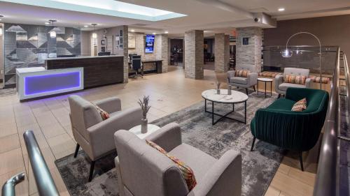 a lobby with a waiting area with chairs and a tv at Best Western Plus Raleigh Crabtree Valley Hotel in Raleigh