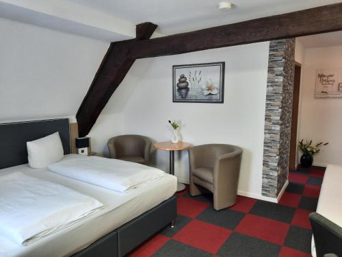 um quarto de hotel com uma cama, uma mesa e cadeiras em Hotel Luca em Betzenstein