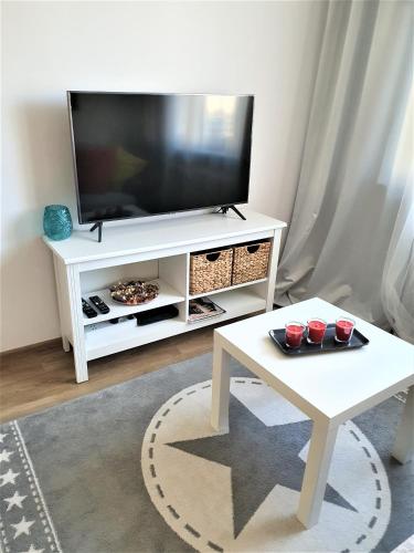 a living room with a television on a white entertainment center at LiLi - Mieszkanie 800m od plaży Brzeźno - AZW Gdańsk in Gdańsk