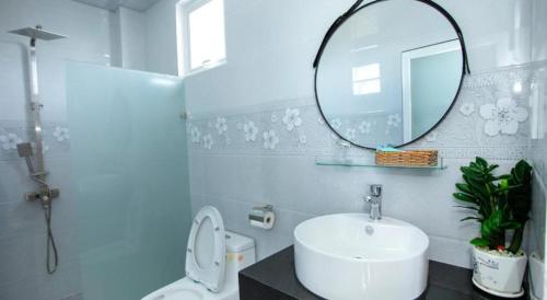 a bathroom with a sink and a mirror and a toilet at HOÀNG KIM HOTEL in Liên Trì (3)