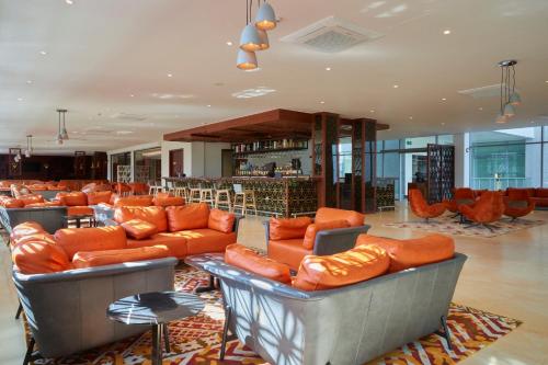 a lobby with orange leather couches and a bar at The Quorum in Lusaka
