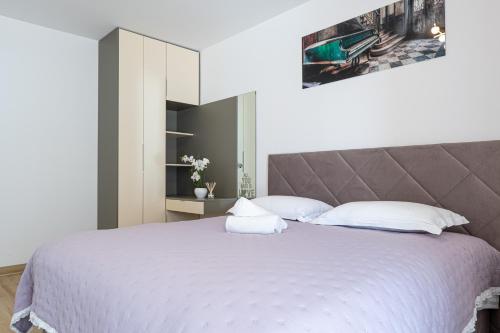 a bedroom with a large bed with white pillows at Ledeno more Luxury Apartments in Split