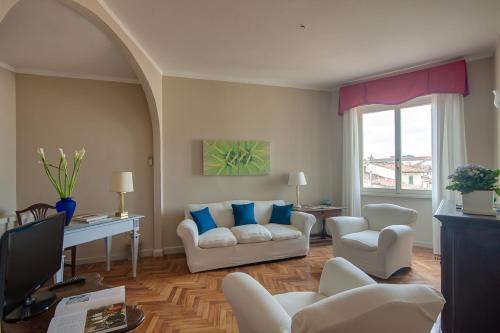 sala de estar con 2 sofás blancos y almohadas azules en Apartments Florence- Palazzo Pitti, en Florencia