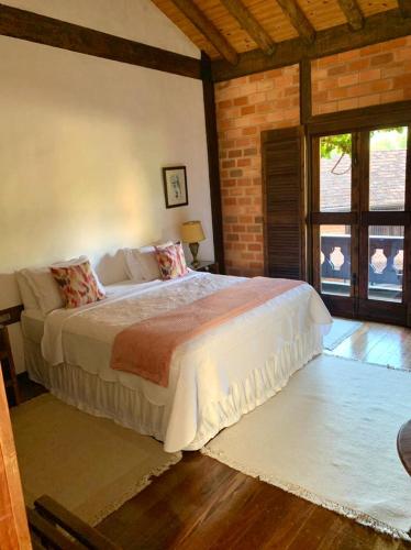 a bedroom with a large bed and a brick wall at Pousada Pedra Azul in Pedra Azul