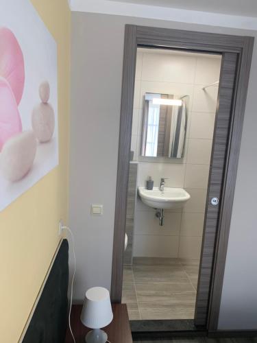 a bathroom with a mirror and a sink at Hotel Restaurant La Piazza in Valkenburg