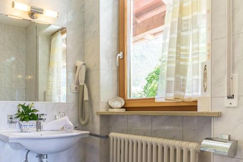 baño con lavabo y ventana en Hotel Montani, en Morter