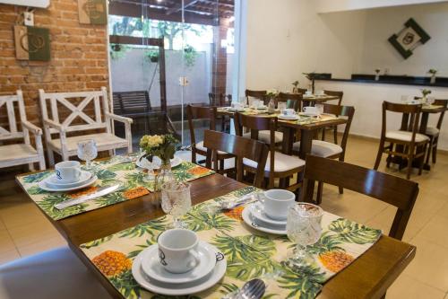 a dining room with a table with plates and cups at Hotel Rio in Guarujá