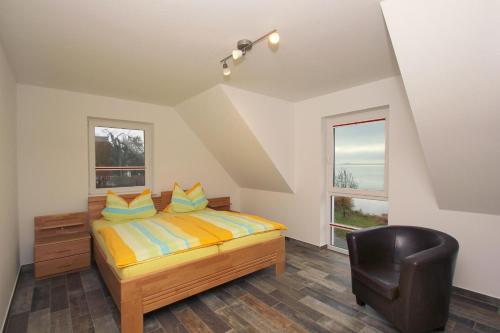 a bedroom with a bed and a black chair at F-1037 Ferienhaus Neuendorf Haus Terrasse, Gartennutzung, Meerblick in Lauterbach