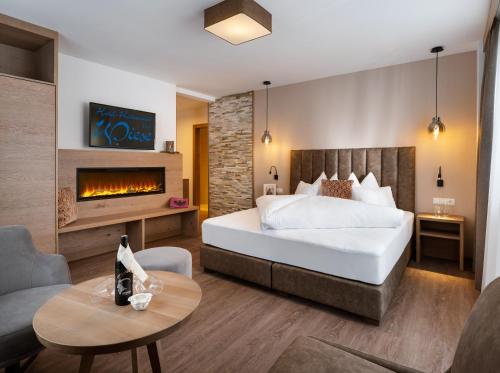 a bedroom with a large bed and a fireplace at Hotel Wiese in Sankt Leonhard im Pitztal