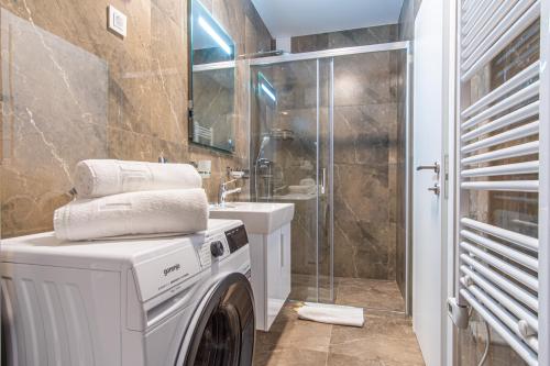 a washing machine in a bathroom with a shower at Ledeno more Luxury Apartments in Split