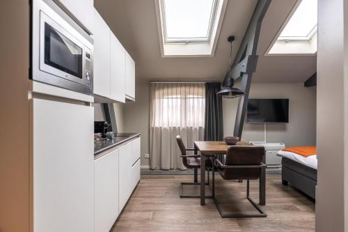 a kitchen with a table and a room with a bed at YAYS Amsterdam Maritime by Numa in Amsterdam