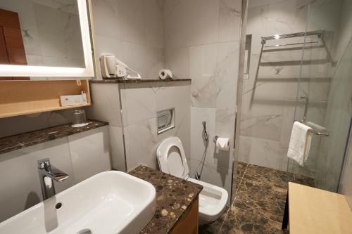 a bathroom with a sink and a toilet and a shower at The Quorum in Lusaka