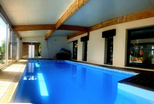 une piscine avec de l'eau bleue dans une maison dans l'établissement Maison conviviale 8 personne avec piscine intérieure, à la campagne, à Saint-Pardoux-le-Vieux