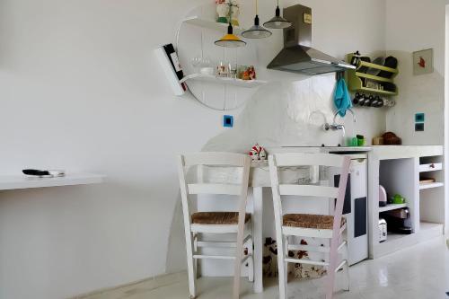 a kitchen with white counters and white stools at Pefkos Eye in Pefki Rhodes