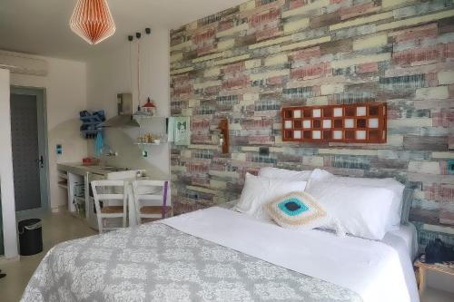 a bedroom with a white bed and a brick wall at Pefkos Eye in Pefki Rhodes