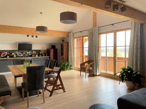 eine Küche und ein Wohnzimmer mit einem Tisch und Stühlen in der Unterkunft Pension Bernhardhof in Otterfing
