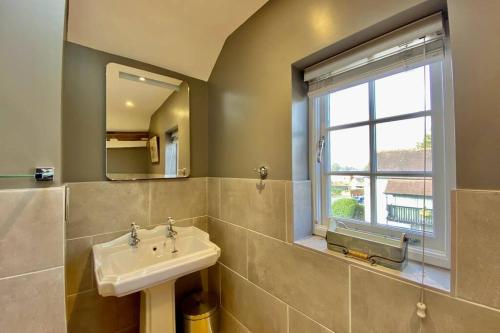 a bathroom with a sink and a window at Tilly's a perfect apartment in the Market Town of Ledbury in Ledbury