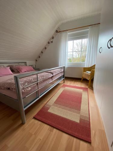 um quarto com uma cama, um tapete e uma janela em Ferienhaus am Hammrich em Leer