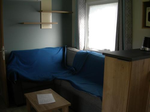 a blue couch in a living room with a window at camping le montourey à fréjus 83600 in Fréjus