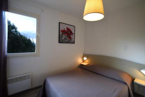 1 Schlafzimmer mit 2 Betten und einem Fenster in der Unterkunft Résidence U Nebbiu in Olmeta-di-Tuda