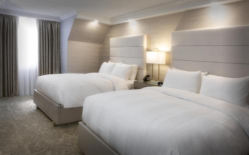 a hotel room with two beds and a window at Chateau Vaudreuil in Vaudreuil-Dorion