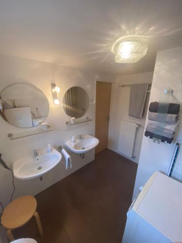 uma casa de banho com dois lavatórios e dois espelhos em Ferienhaus am Hammrich em Leer