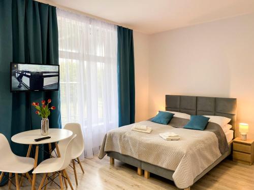 1 dormitorio con 1 cama y 1 mesa con sillas en Bałtycka Osada en Jarosławiec