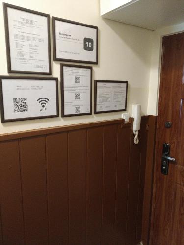 a row of framed certificates on a shelf in a bathroom at Szent Miklós Apartman in Hajdúszoboszló
