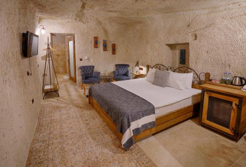 a bedroom with a large bed in a stone room at Henna Hotel-Adults Only in Goreme