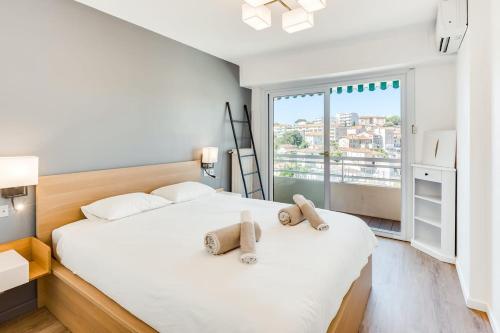 une chambre avec un lit avec deux animaux en peluche dessus dans l'établissement Petit Juas Apartment, à Cannes