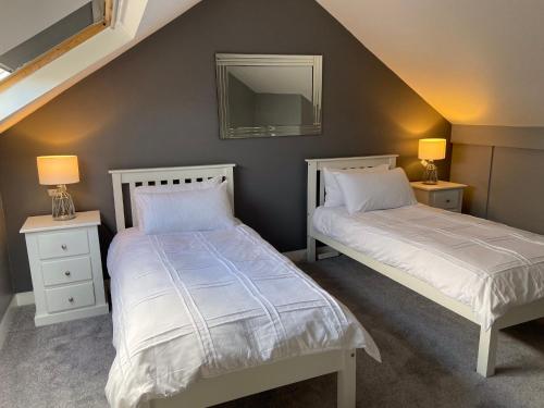 a bedroom with two beds and a mirror on the wall at Bridge street apartment in Bridlington