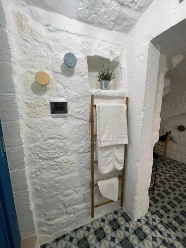 a bathroom with white towels on a wall at La Casetta 21 in Polignano a Mare