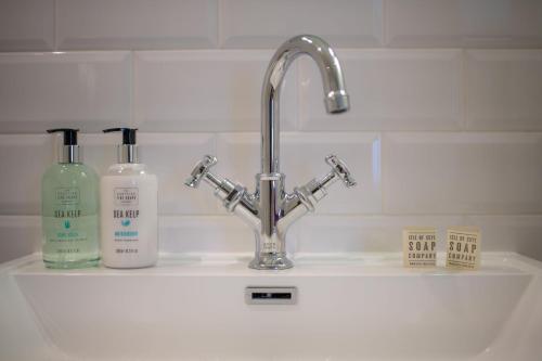 a sink with two bottles of detergents on it at The Skye Inn in Portree